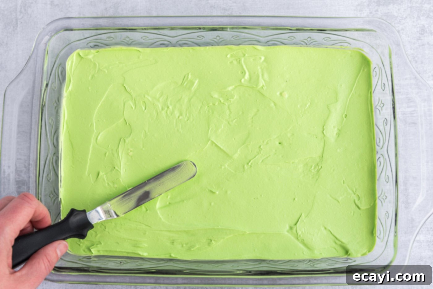 No-Bake Mint Chocolate Lasagna 9 icing spatula spreading cream cheese mixture in a pan