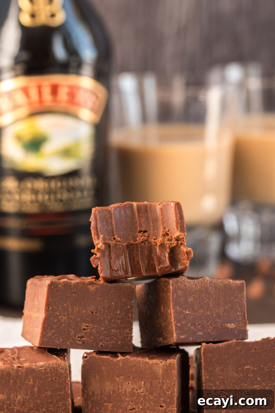 Effortless 4 Ingredient Baileys Fudge 3 Stack of Bailey's fudge squares, one with a bite taken out, showcasing the creamy texture