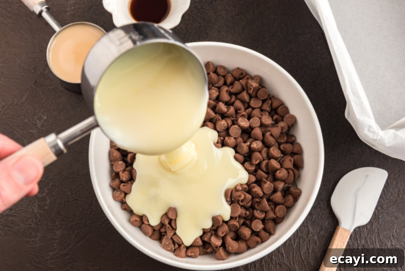 Effortless 4 Ingredient Baileys Fudge 5 Pouring sweetened condensed milk over a bowl of chocolate chips