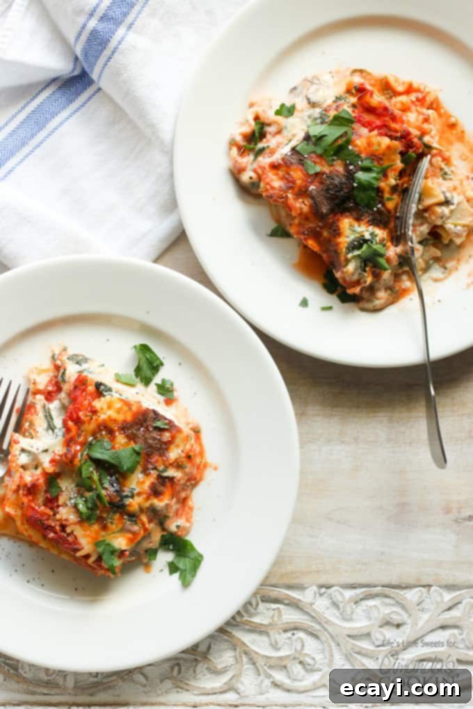 Garden Vegetable Lasagna 5 An overhead picture of two white plates with a serving of veggie lasagna on top.