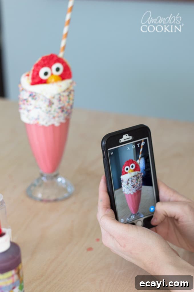 Elmo Freakshakes A person capturing a photo of a beautifully crafted Elmo Freakshake, highlighting its Instagram-worthy presentation.