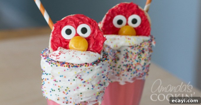 Elmo Freakshakes- super easy and super cute! A close-up view of an Elmo cookie perched on a cloud of whipped cream atop a red milkshake, ready to be enjoyed.