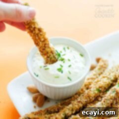 Crispy Almond Parmesan Asparagus Fries 5 asparagus fries being dipped in sauce