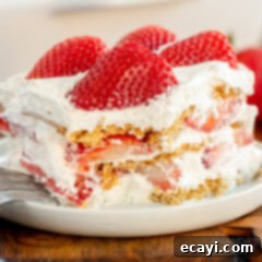 Strawberry Cloud Cake 12 strawberry icebox cake with a bite taken out, showing the soft layers