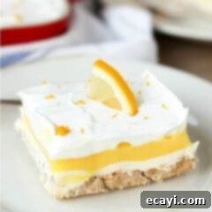Lemon Velvet Delight 2 A piece of layered lemon dessert on a plate