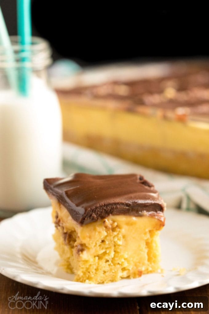Boston Cream Poke Cake slice of boston cream poke cake on a white plate with bottle of milk in background