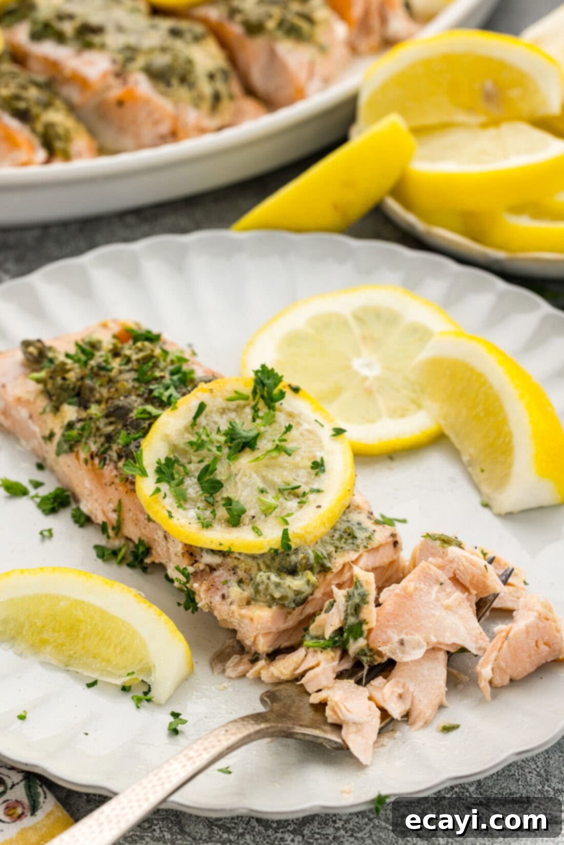 Zesty Lemon Caper Salmon 9 Lemon Caper Salmon filet broken apart on a plate
