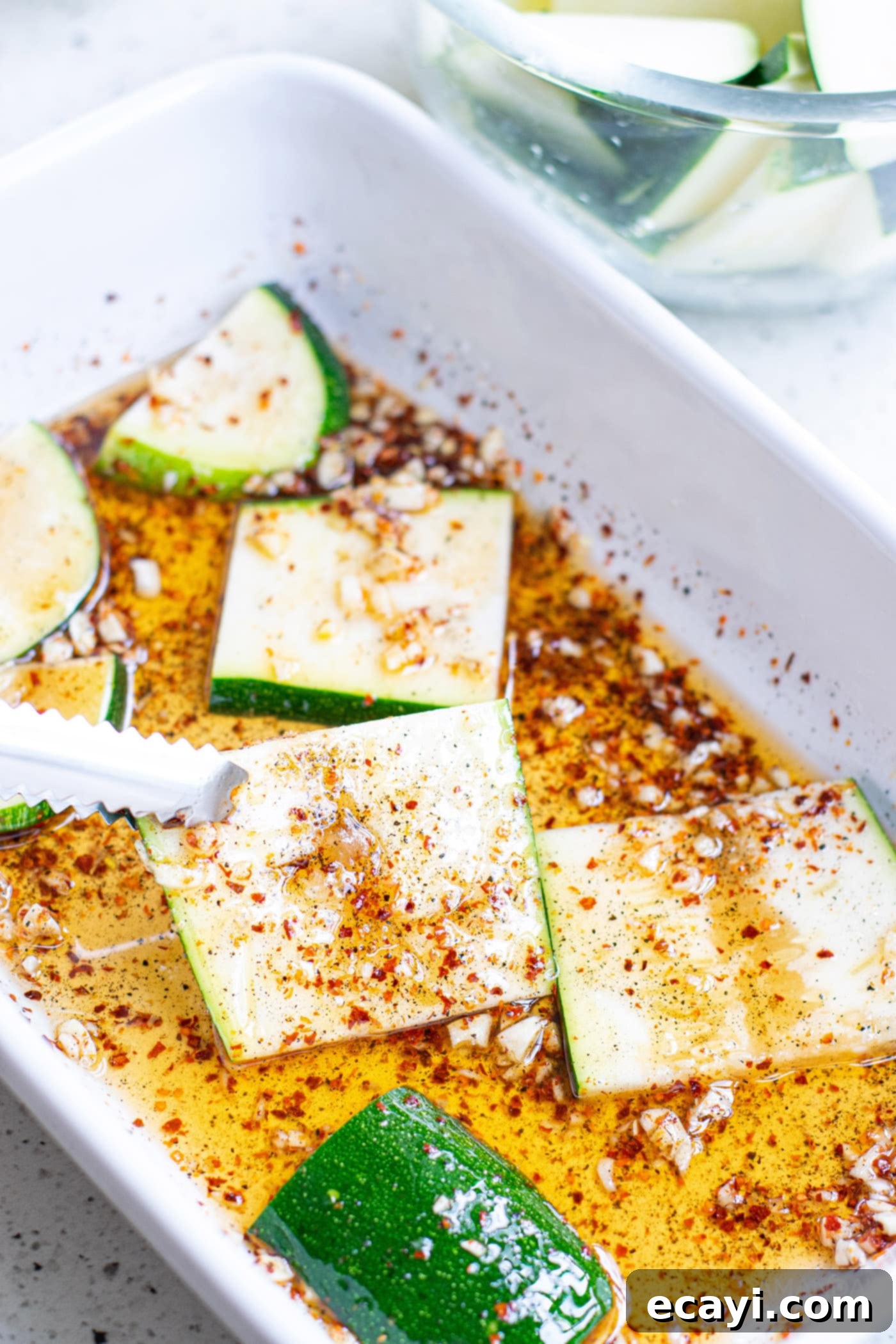 Grilled Corn, Zucchini and Feta Salad 6 Sliced zucchini marinating in a bowl with spices and olive oil.