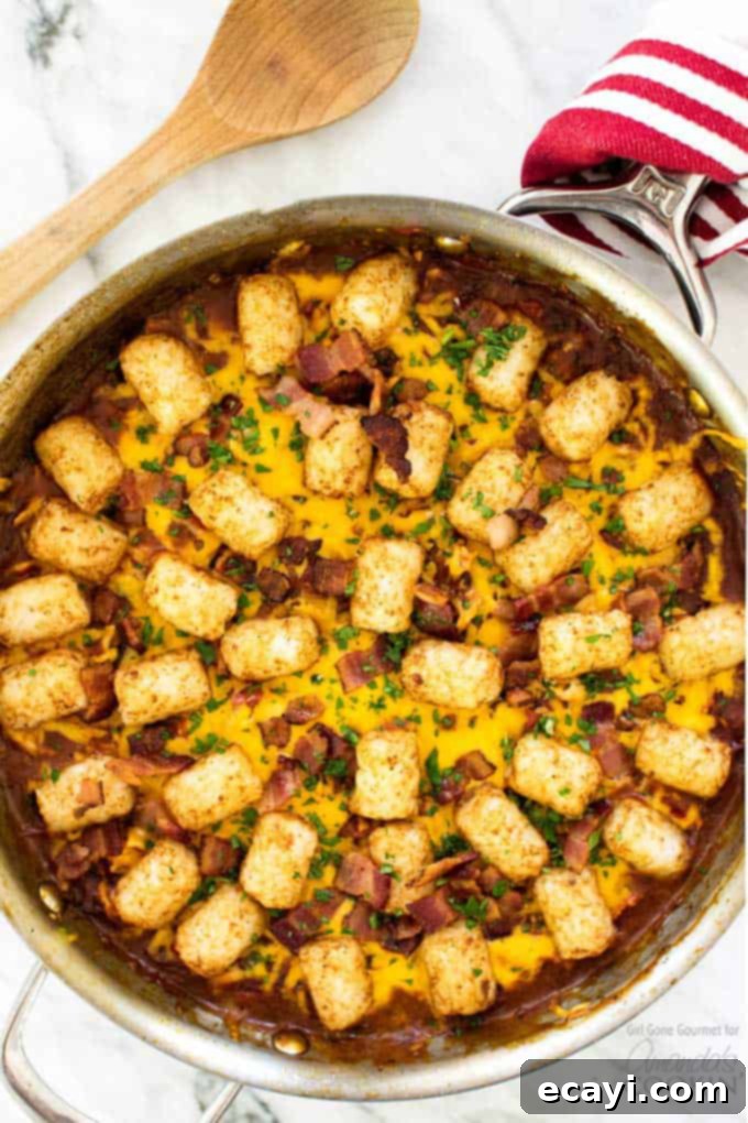 A delicious BBQ Chicken Tater Tot Skillet with crispy tater tots, melted cheese, and tender chicken. Overhead shot of a BBQ Chicken Tater Tot Skillet, golden brown and bubbly, garnished with fresh parsley.