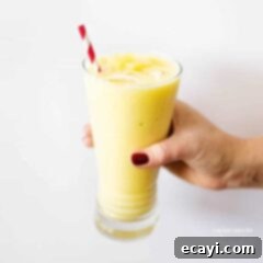 Pina Colada Paradise Smoothie 5 hand holding glass of pina colada smoothie