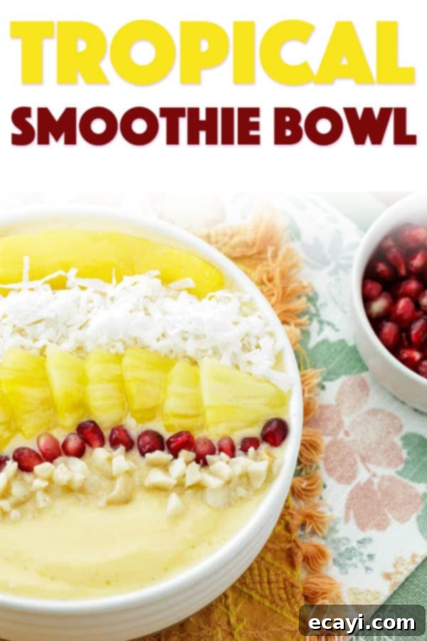 This refreshing tropical smoothie bowl is bursting with flavor and reminds me of a bowl of sunshine! This smoothie bowl is perfect for summer. #tropical #smoothie #smoothiebowl #breakfast #fruit #dairyfree #mango #peach #coconut A beautifully presented Tropical Smoothie Bowl from an overhead shot, rich with colors and textures from the fruit and nut toppings