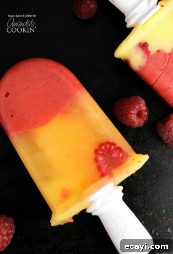 Refreshing Raspberry Mango Popsicles 4 Adult friendly vodka and limoncello infused mango raspberry popsicles, showing the distinct fruit layers.