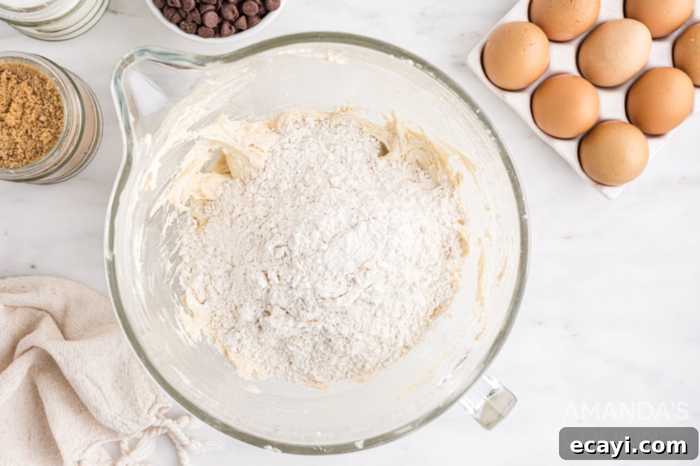 Decadent Skillet Chocolate Chip Cookie 7 Flour mixture being added to the wet cookie dough ingredients in a bowl.