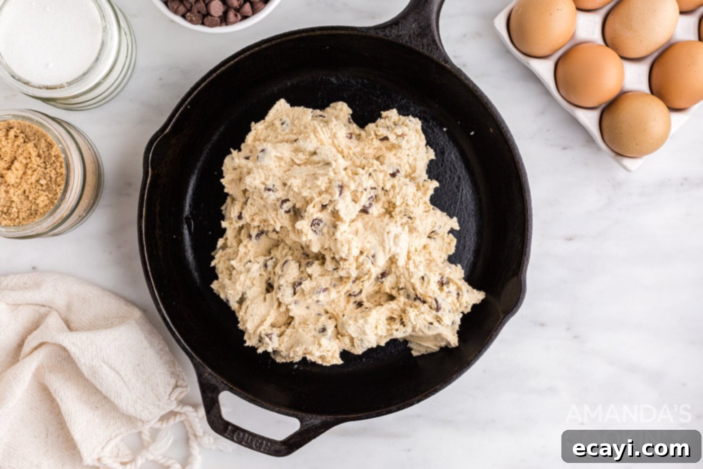 Decadent Skillet Chocolate Chip Cookie 9 Raw chocolate chip cookie dough pressed evenly into a cast iron skillet, ready for baking.