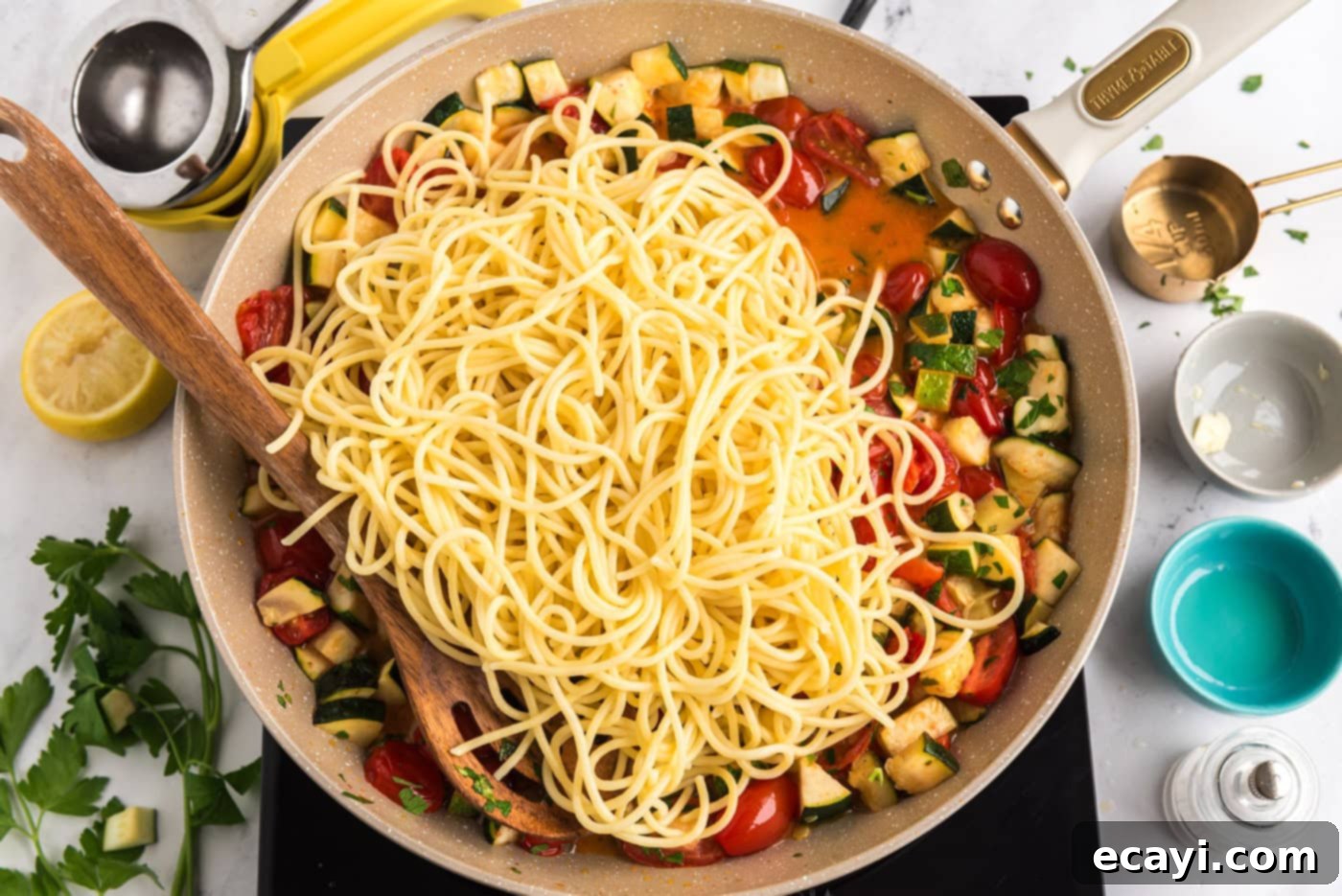Summer Zucchini Tomato Pasta 9 Cooked pasta being added directly to a skillet with the zucchini and tomato sauce, ready to be tossed.