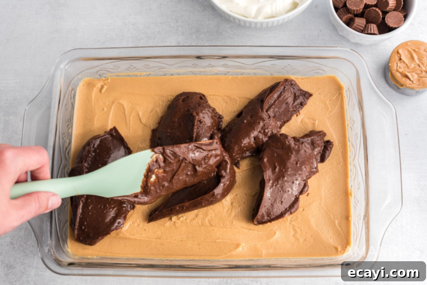 Decadent Chocolate Peanut Butter Stack 12 rubber spatula spreading chocolate pudding over peanut butter