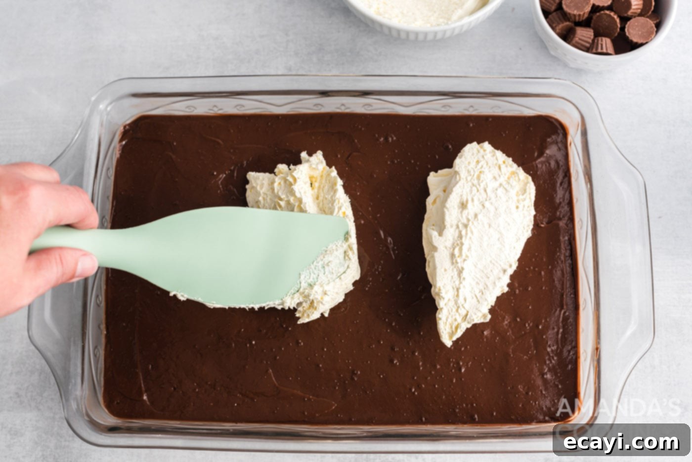 Decadent Chocolate Peanut Butter Stack 13 rubber spatula spreading whipped topping over chocolate pudding