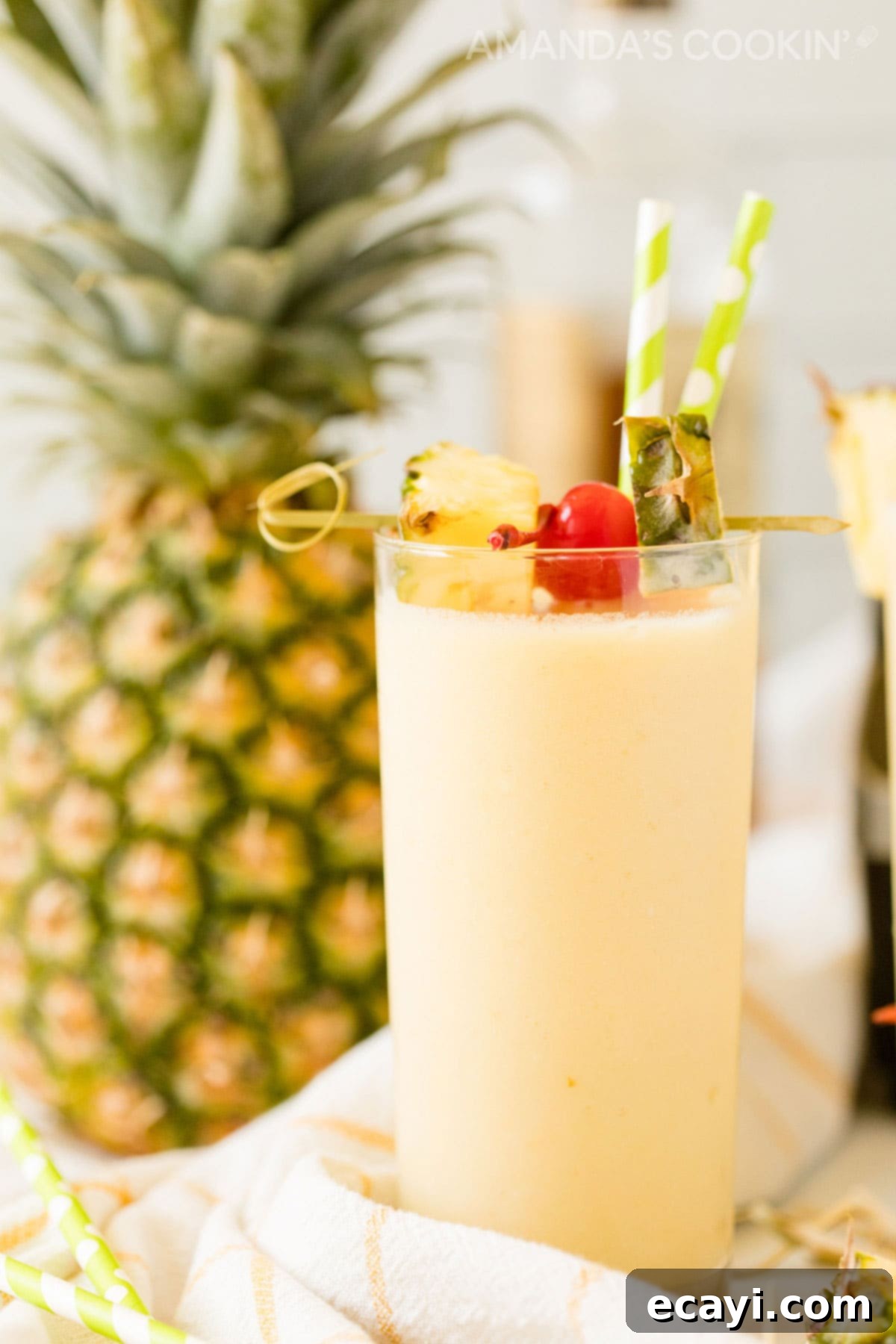 With only 3 ingredients, this pineapple rum slush is one of our favorite frozen rum drinks! A quick cocktail that's perfect for a crowd on a hot summer day. Side view of a vibrant pineapple rum slush cocktail with a pineapple slice garnish