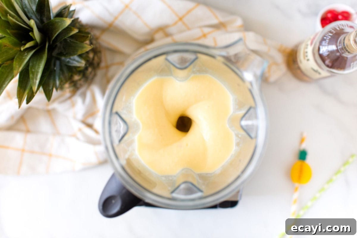 Tropical Rum Slushy 5 Pineapple rum slush being blended to a smooth consistency in a blender
