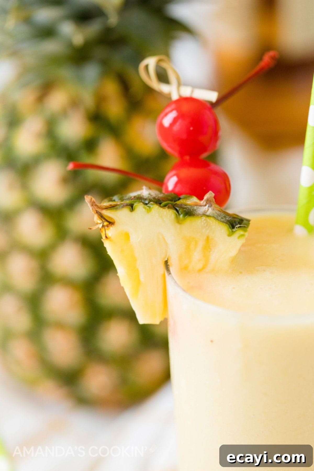 With only 3 ingredients, this pineapple rum slush is one of our favorite frozen rum drinks! A quick cocktail that's perfect for a crowd on a hot summer day. Close-up of a pineapple rum slush cocktail with cherry and pineapple garnishes