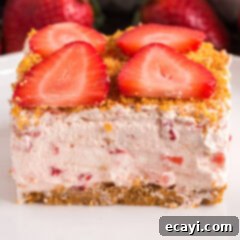 Blush Berry Bliss 14 Close up photo of a slice of Strawberry Dream Dessert, highlighting the creamy layers and fresh strawberry pieces.
