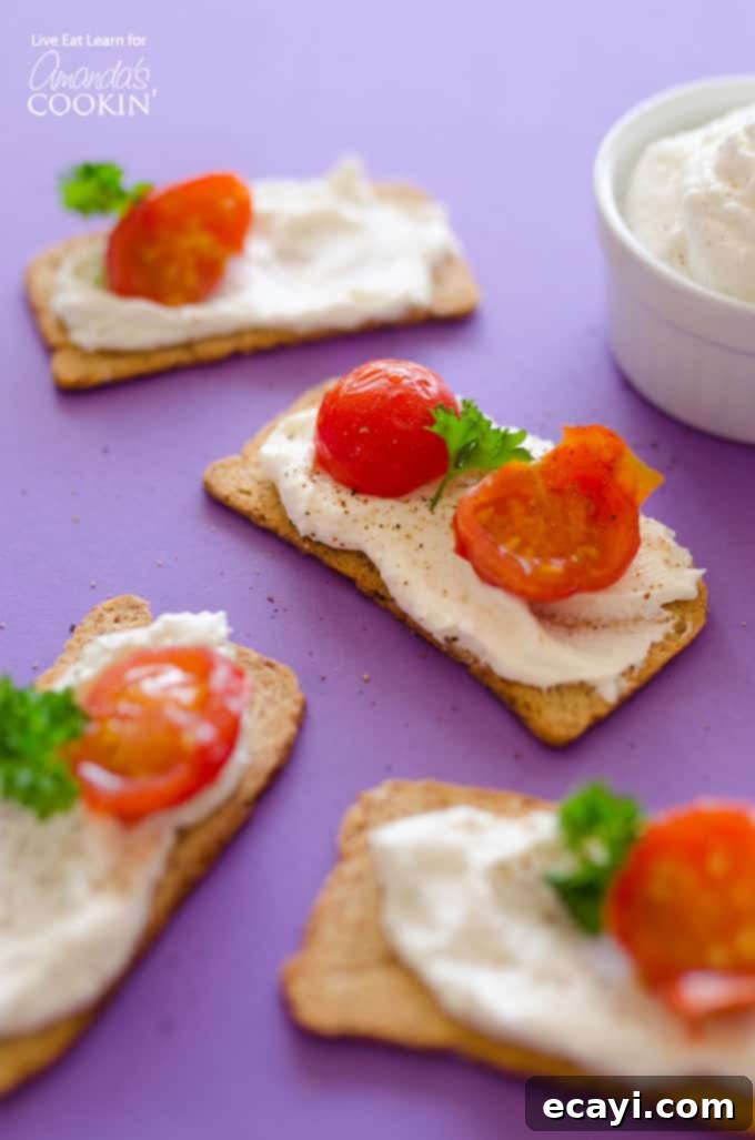 Delicious and Creamy Ricotta Whipped Feta: A Versatile Mediterranean Cheese Spread for Any Occasion Ricotta Whipped Feta on crackers with cherry tomatoes and fresh herbs, ready to serve