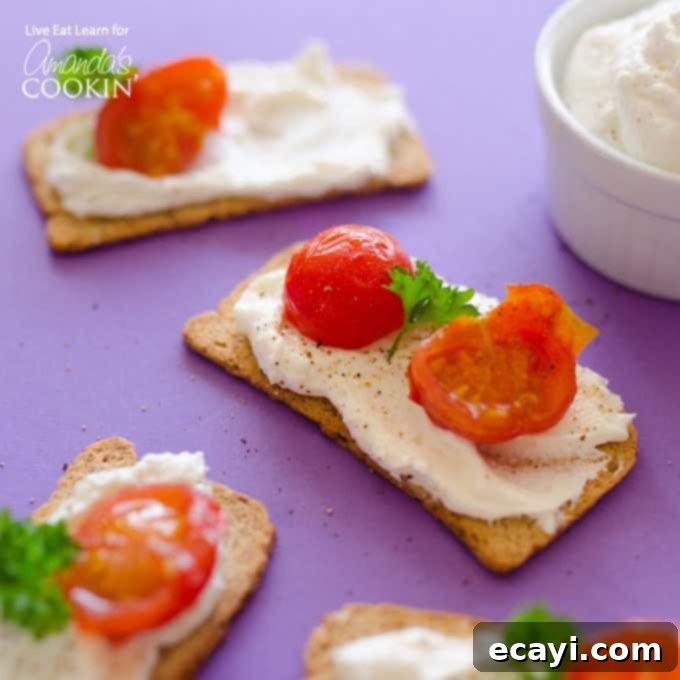 Enjoying Ricotta Whipped Feta: A Perfect Snack or Appetizer for Parties and Gatherings Serving of Ricotta Whipped Feta on crackers, garnished with fresh cherry tomatoes and basil