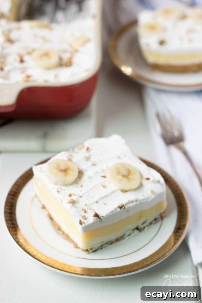 Ultimate Banana Cream Lush with Bananas Foster: A layered dessert experience like no other. Banana Cream Lush slice on plate