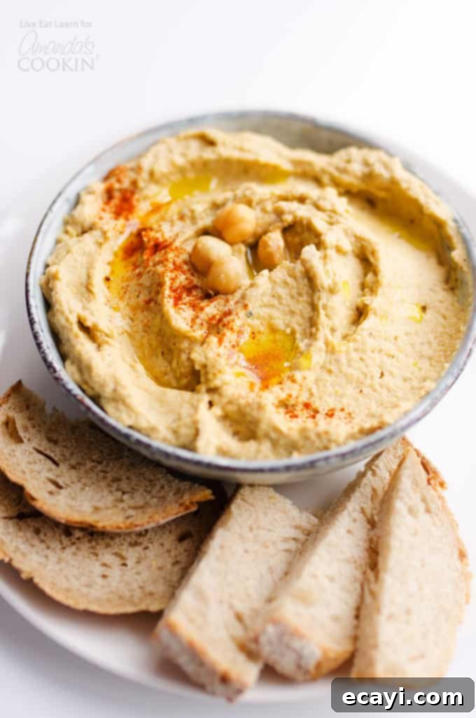 Experience the delightful fusion of rich eggplant and creamy chickpeas with this versatile Baba Ganoush Hummus, perfect for spreading on everything! #eggplant #hummus #vegetarian #chickpeas #healthyrecipes #dips #appetizers Creamy Baba Ganoush Hummus served in a bowl with fresh pita bread and vegetables