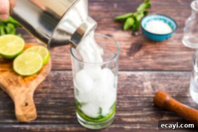 Island Coconut Dream 13 straining coconut mojito into a glass