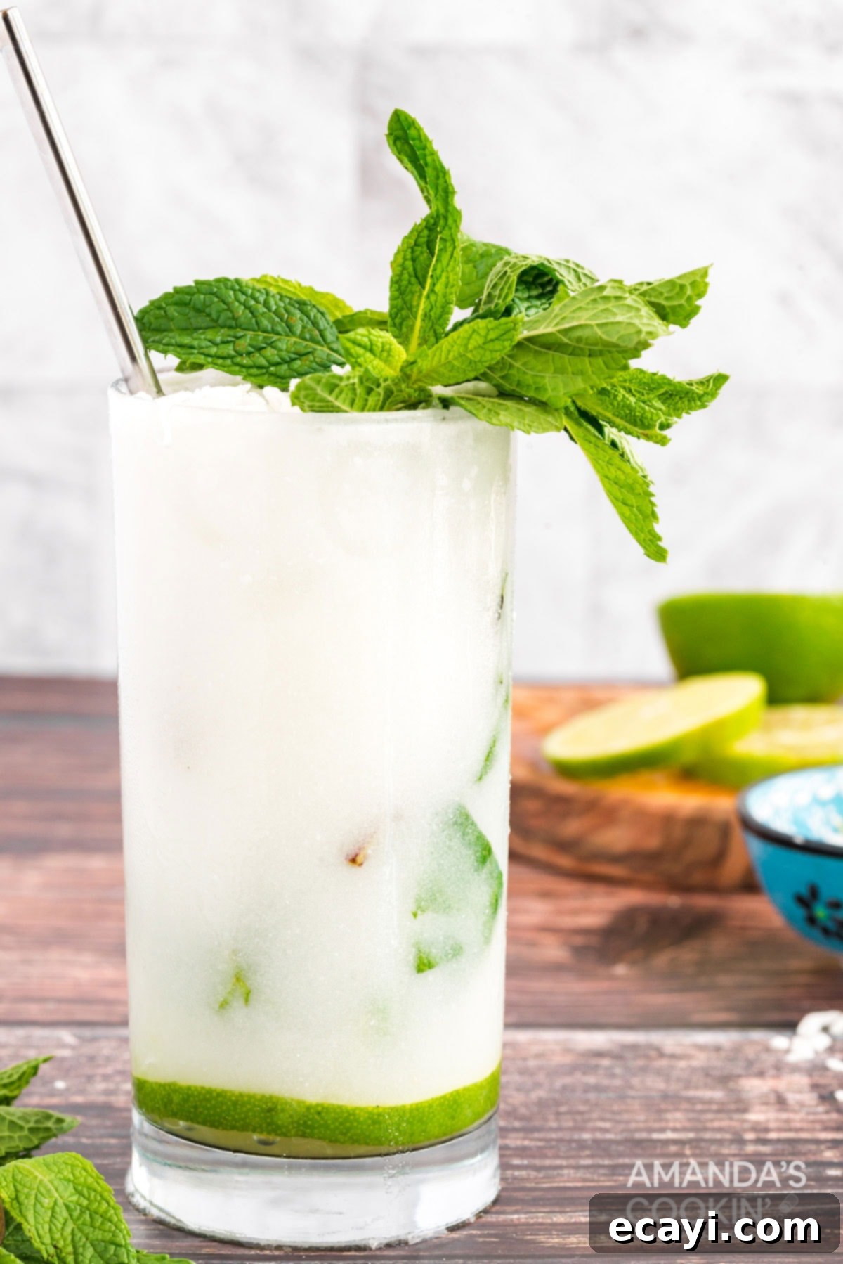 This refreshing Coconut Mojito is made with fresh cooling mint, coconut rum, coconut cream and club soda. A delicious and tropical cocktail for summer! glass of mojito made with coconut rum