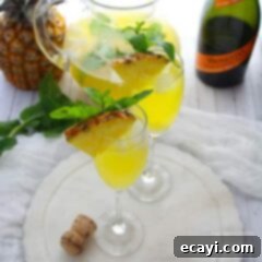 Pineapple Prosecco Fiesta 2 Delicious Pineapple Prosecco Punch in a glass, ready to be enjoyed at brunch or a party.
