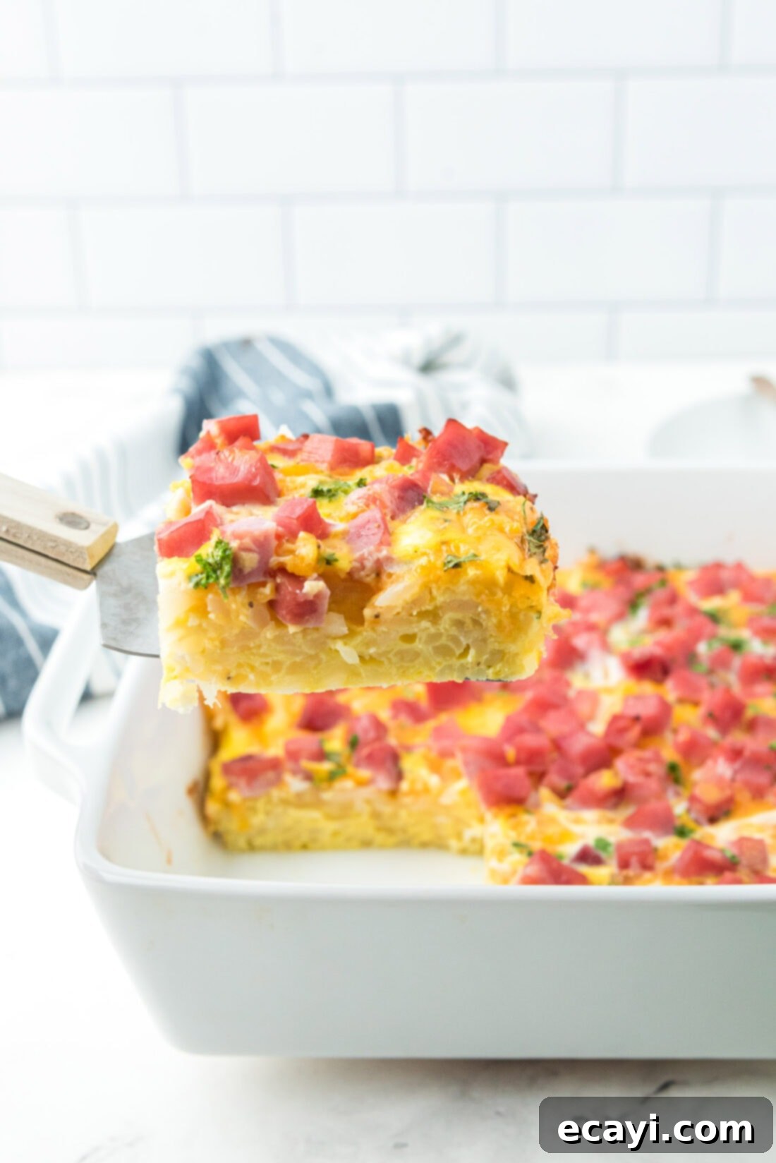 Savory Ham and Cheese Morning Bake 3 Spatula lifting a portion of Breakfast casserole