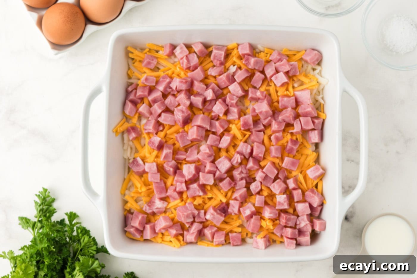 Savory Ham and Cheese Morning Bake 7 Cubed ham on top of cheese in casserole dish, ready for egg mixture