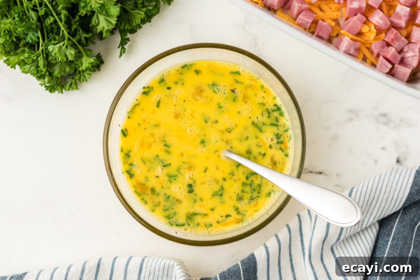 Savory Ham and Cheese Morning Bake 8 Egg and parsley mixture in a bowl, perfectly beaten