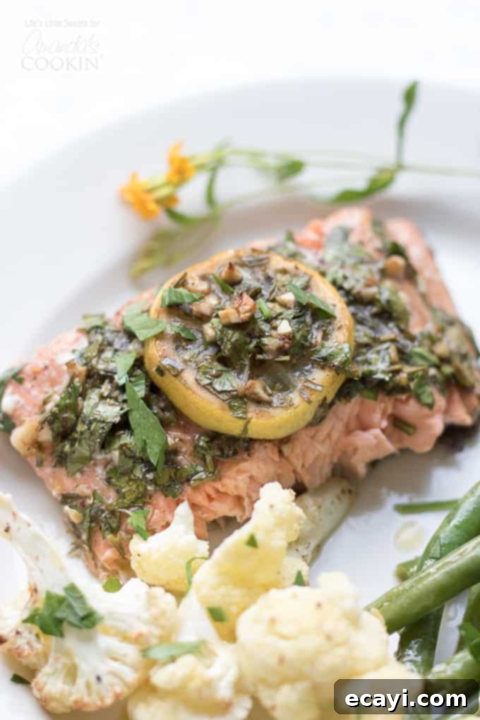 Easy 30-Minute Sheet Pan Salmon Dinner with Lemon, Tarragon, and Roasted Vegetables Sheet Pan Salmon with lemon slices and fresh tarragon on top, surrounded by roasted cauliflower and green beans, ready to serve.