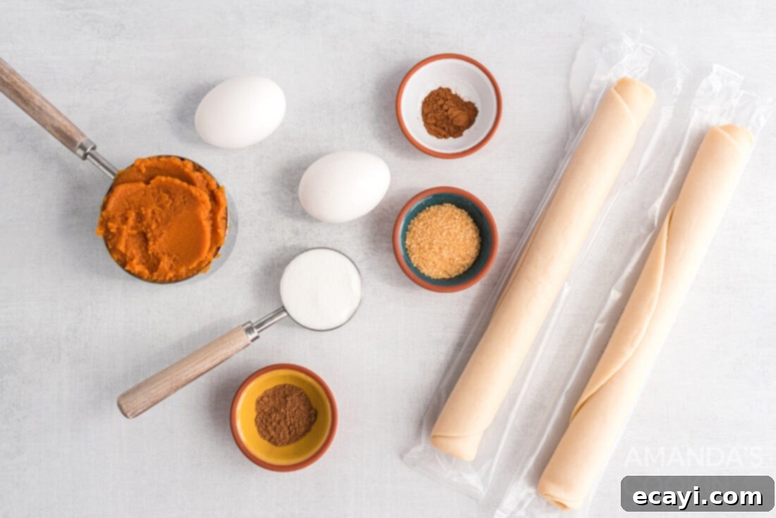Flaky Pumpkin Turnovers 4 Collection of ingredients laid out for making Pumpkin Hand Pies: pumpkin puree, sugar, egg, pumpkin spice, pie crust
