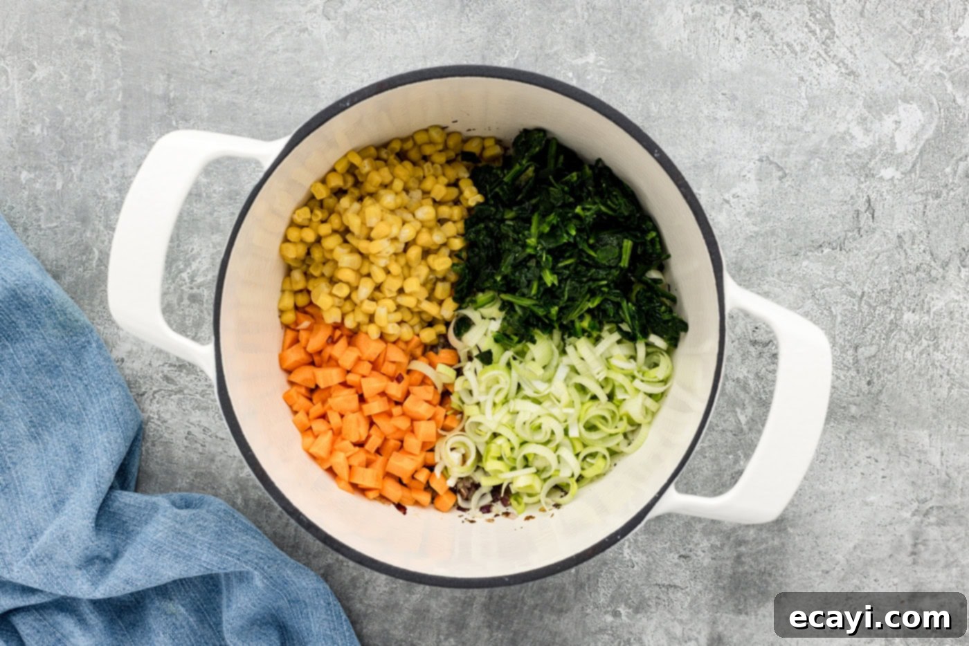 Hearty Veggie Rice Soup 6 spinach, corn, carrots, and leeks added to a soup pot, stirring them with the onions and spices