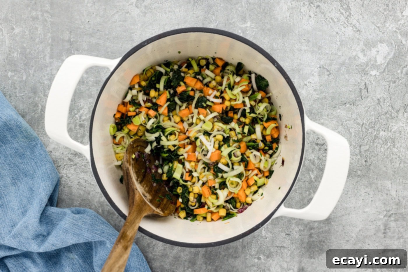 Hearty Veggie Rice Soup 7 vegetables mixed in a pot with a spoon, showing a colorful medley