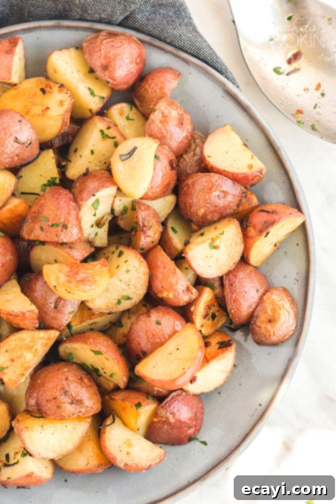 These golden roasted potatoes make the perfect Thanksgiving side dish. These potatoes are perfectly seasoned with rosemary and garlic! #thanksgiving #easter #holidaysides #holidaydish #easterdinner #dinnersides #sidedish #potatoes #garlic #christmasdinner roasted potatoes on a plate