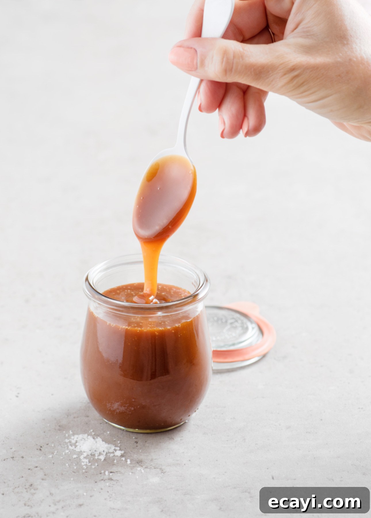 A jar of homemade salted caramel sauce, ready to be used as a topping or filling.