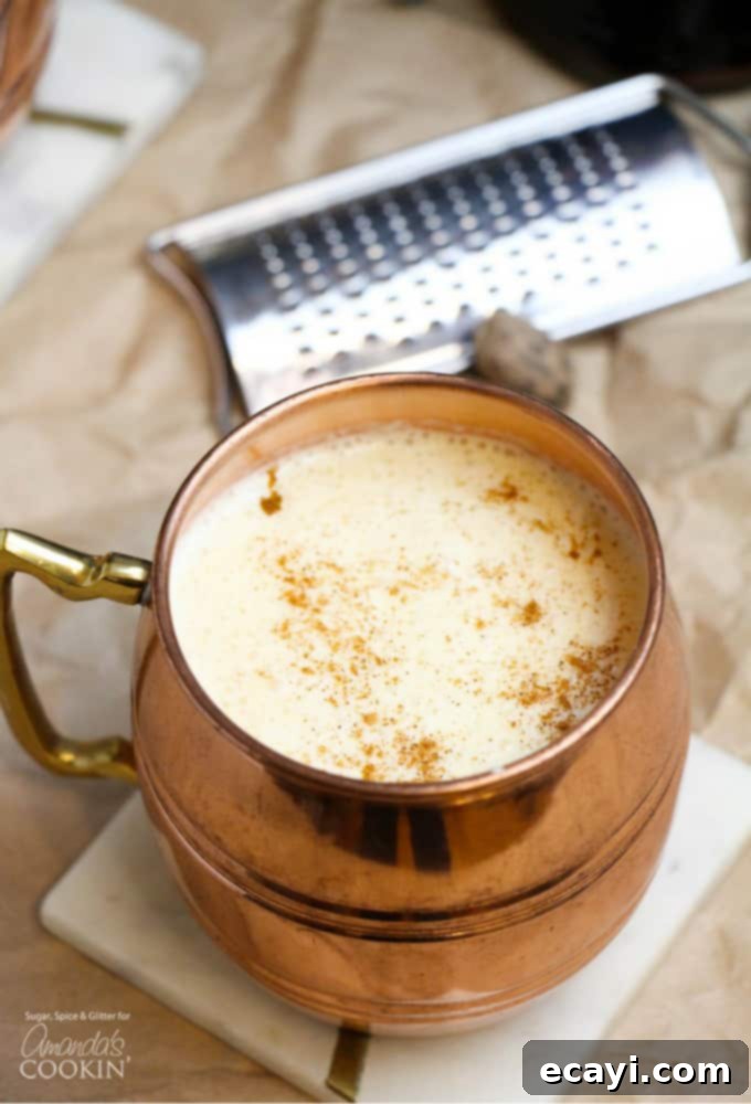 Homemade Eggnog Cocktail: A thick, rich, and flavorful holiday drink made with eggs, sugar, milk, cream, rum, and nutmeg. Perfect for your festive party. Rich and creamy homemade eggnog cocktail in a festive copper mug, garnished with freshly grated nutmeg, ready for holiday celebrations.
