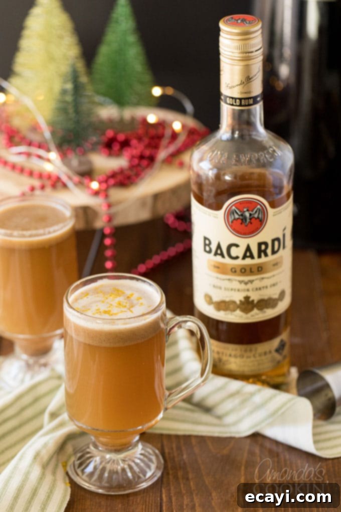 A Hot Buttered Rum - AKA a hot toddy - is a dessert-like cocktail with a rich, buttery flavor that is gently spiced and finished off with a twist of orange. two glasses of hot toddy