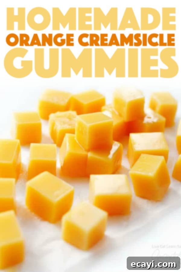 Refreshing and delicious homemade Orange Creamsicle Gummies Close-up of perfectly set easy homemade Orange Creamsicle Gummies in a tray, highlighting their smooth texture and vibrant color.