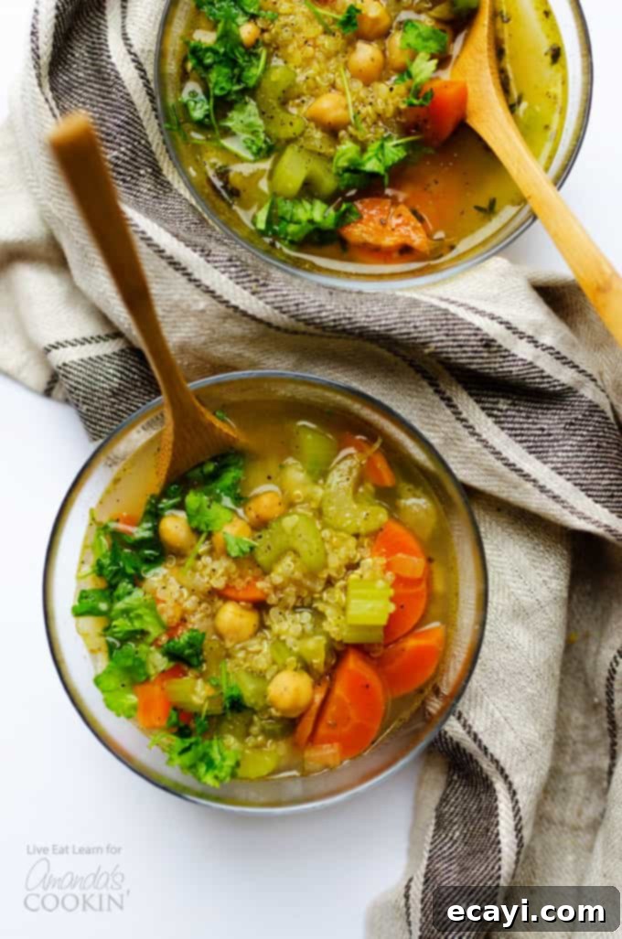 A deliciously healthy vegetable soup with quinoa and chickpeas, perfect for a warming winter meal. #chickpeas #soup #healthy #vegetarian #vegetariansoup #souprecipes #winterrecipes #vegetablesoup #quinoasoup Healthy vegetable soup above shot, brimming with fresh ingredients