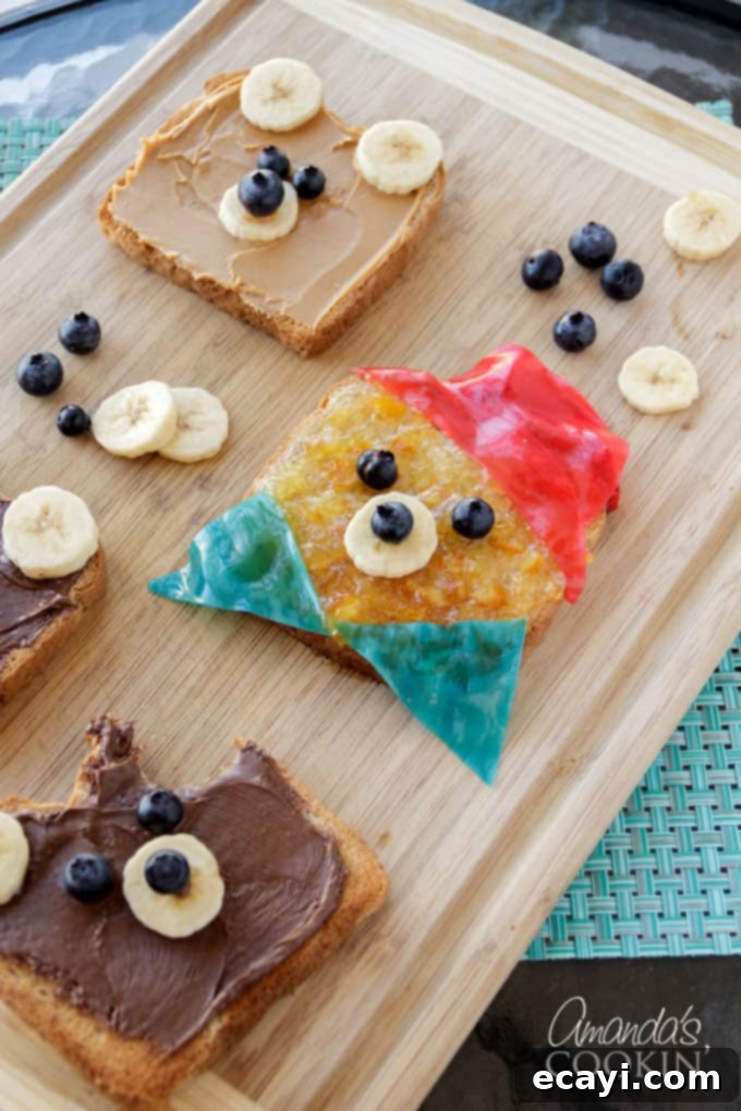 This bear toast requires minimal time and skill, making it an ideal, fun food-craft for kids to help with in less than 10 minutes! Three slices of Paddington Bear toast, artfully arranged on a rustic wooden cutting board, showcasing the detailed fruit decorations that bring the bear to life.