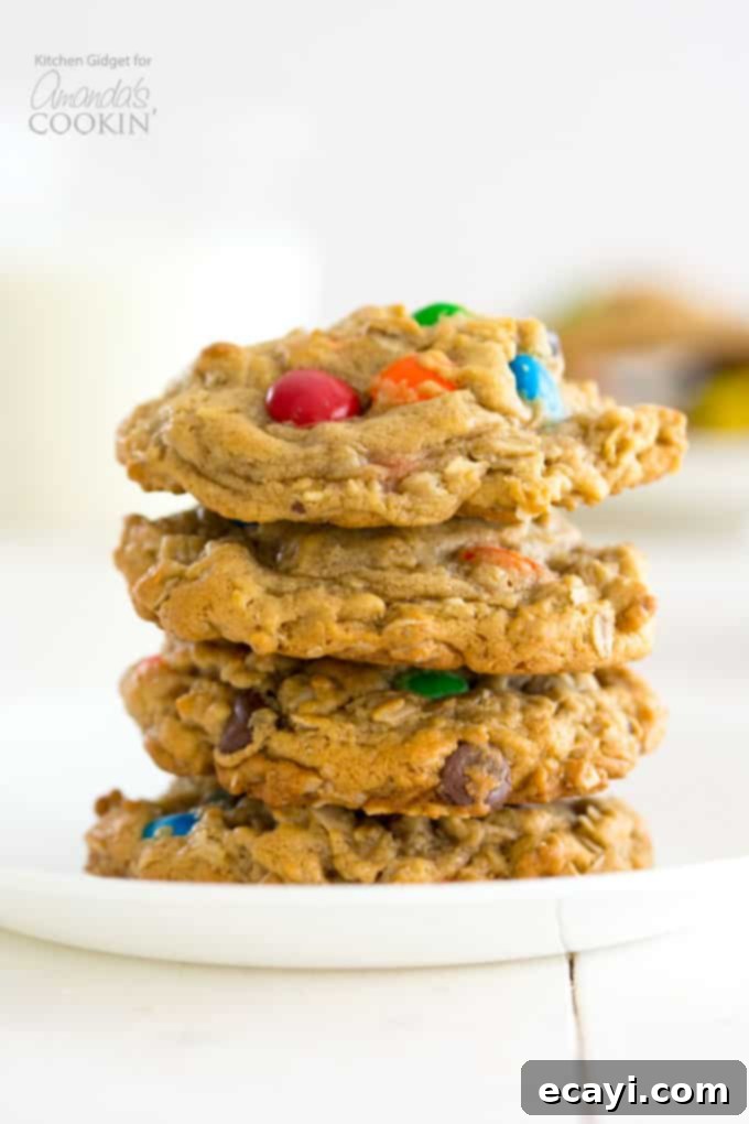 Monster Cookies: peanut butter and oatmeal cookies packed with chocolate chips and colorful M&M's. These cookies are fun to make with the kids! #monstercookies #m&ms #cookierecipes #bestdessertrecipes #chocolate #peanutbutter #peanutbuttercookies #oatmeal #oatmealcookies Stacked chewy Monster Cookies with peanut butter, M&M's, and chocolate chips