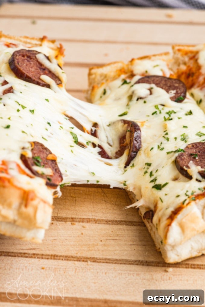 Gooey cheese pull from a homemade French bread pizza, perfect for a quick and satisfying meal. #cheesepizza #frenchbread #easyrecipes #weeknightdinner Close-up of French bread pizza with gooey mozzarella cheese pulling apart