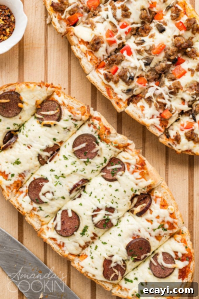 Freshly baked French bread pizza, perfectly sliced and ready to enjoy. #homemadefood #easyrecipes #pizzafordinner Overhead view of a finished French bread pizza sliced on a wooden cutting board