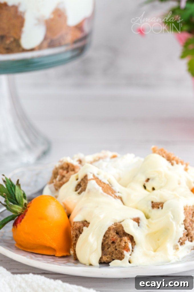 This carrot cake trifle has layers of moist carrot cake and no-bake cheesecake filling then topped with adorable strawberry  serving of carrot cake trifle on a plate